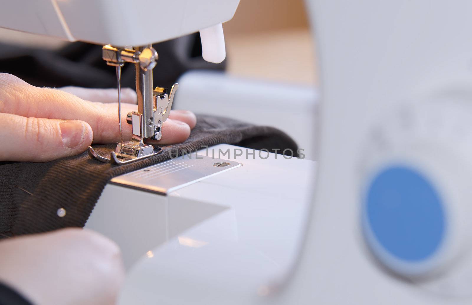  woman hands sewing on the stitching machine