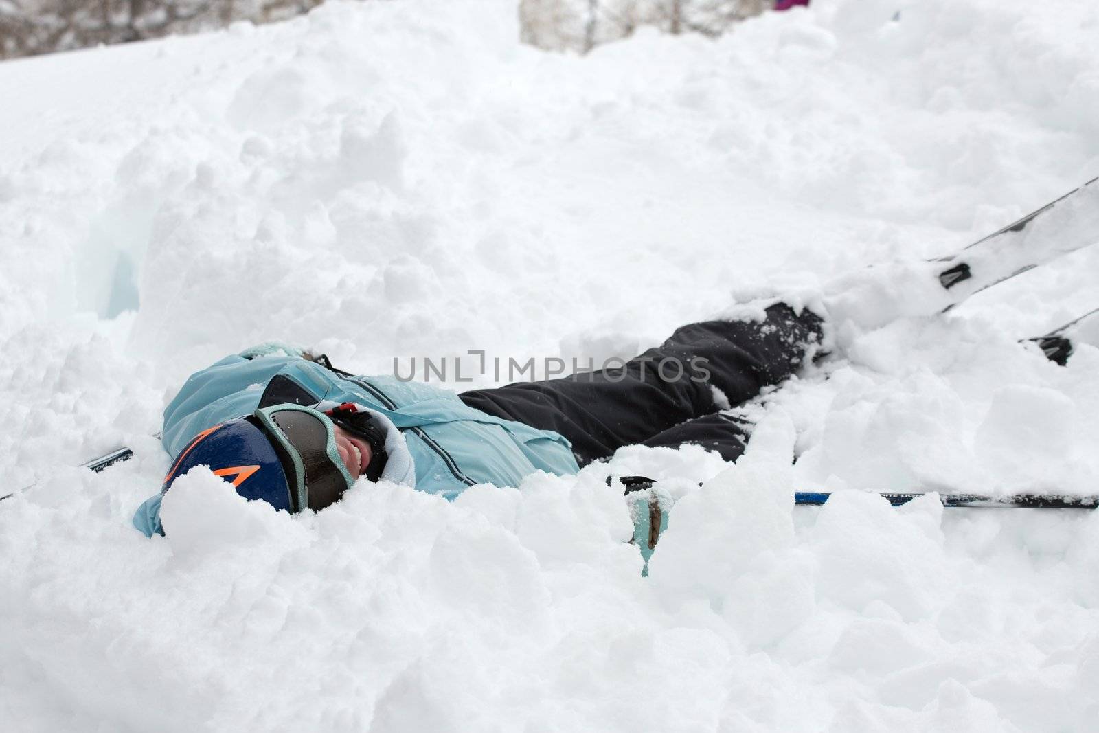Female skier fallen into deep snow 