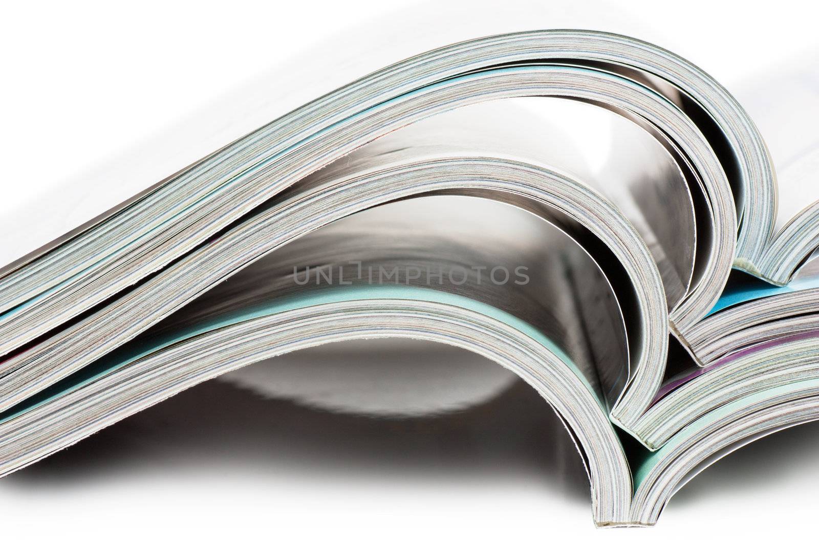 Stack of open magazines over white background
