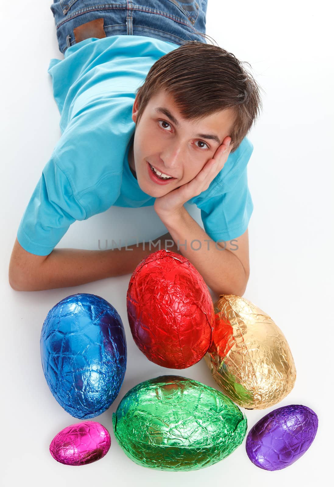 Smiling boy among a small selection of colourful easter eggs.
