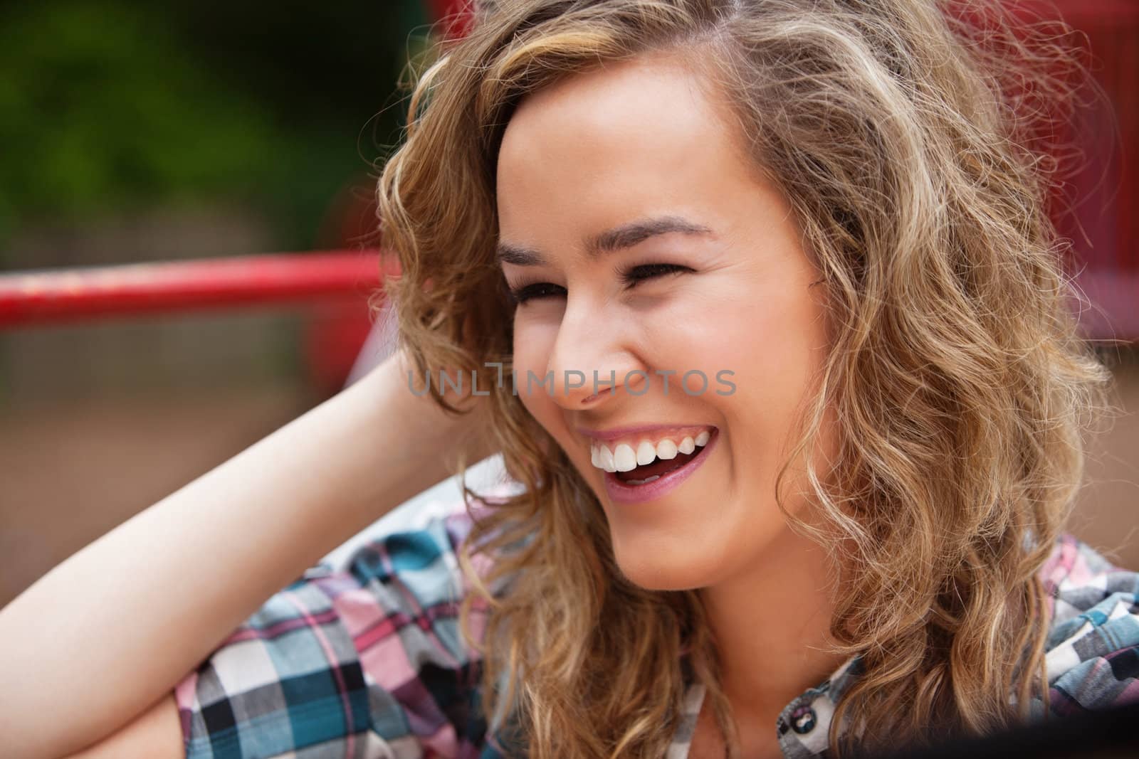 Cheerful young woman laughing by leaf