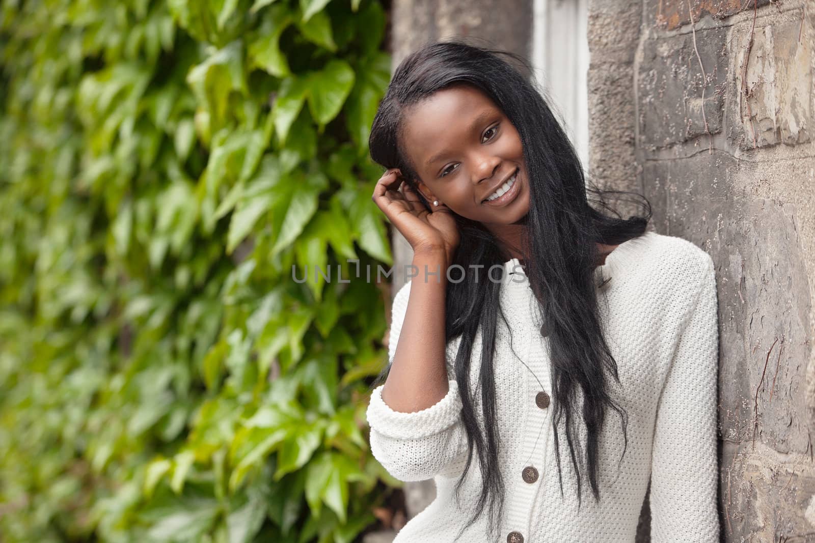 Happy young African American woman standing outdoors and smiling