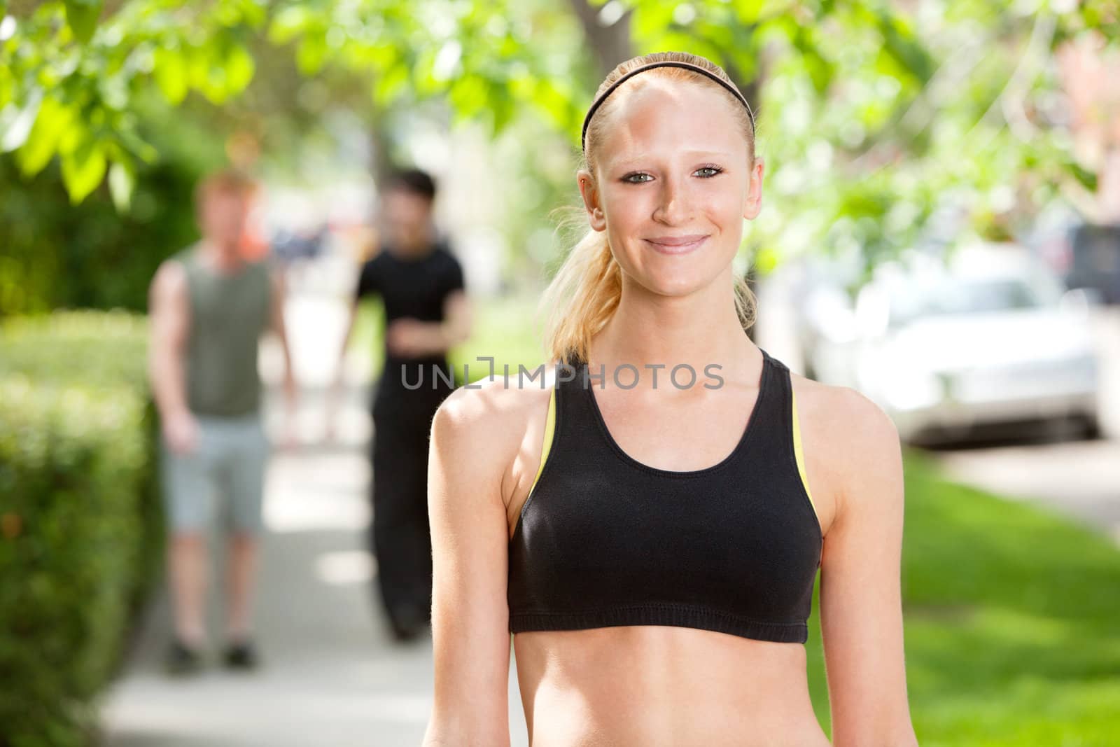 Close-up of a beautiful woman in sports wear with friends in the background