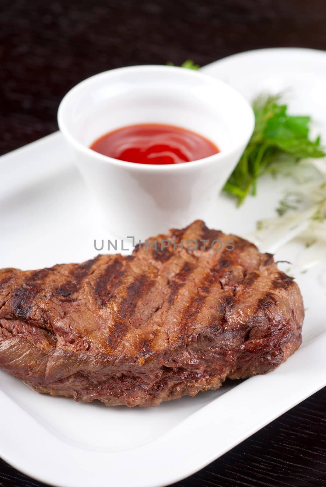 Juicy roasted beef steak with vegetables closeup at plate