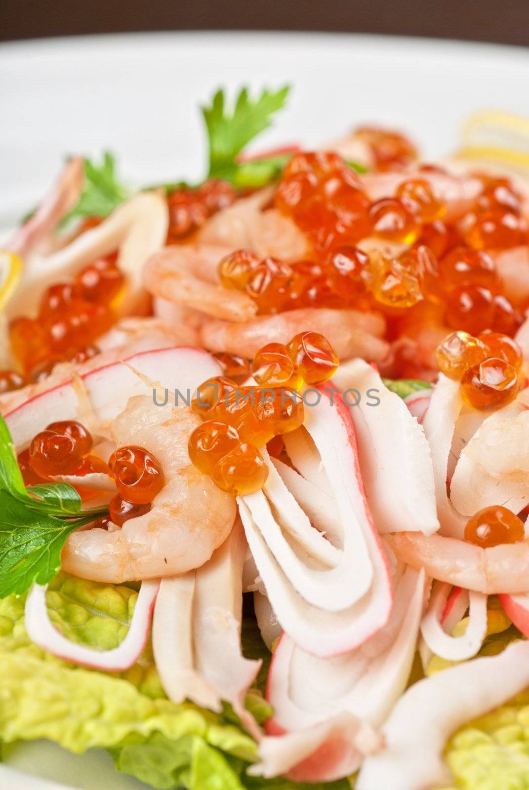 Salad with shrimps, caviar, calamaries, lettuce, lemon and olive