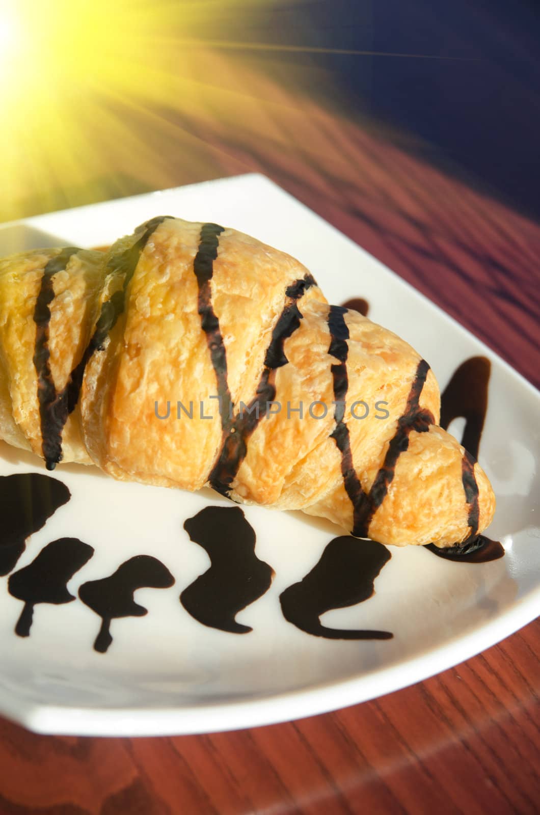 Fresh croissant at white plate, closeup photo