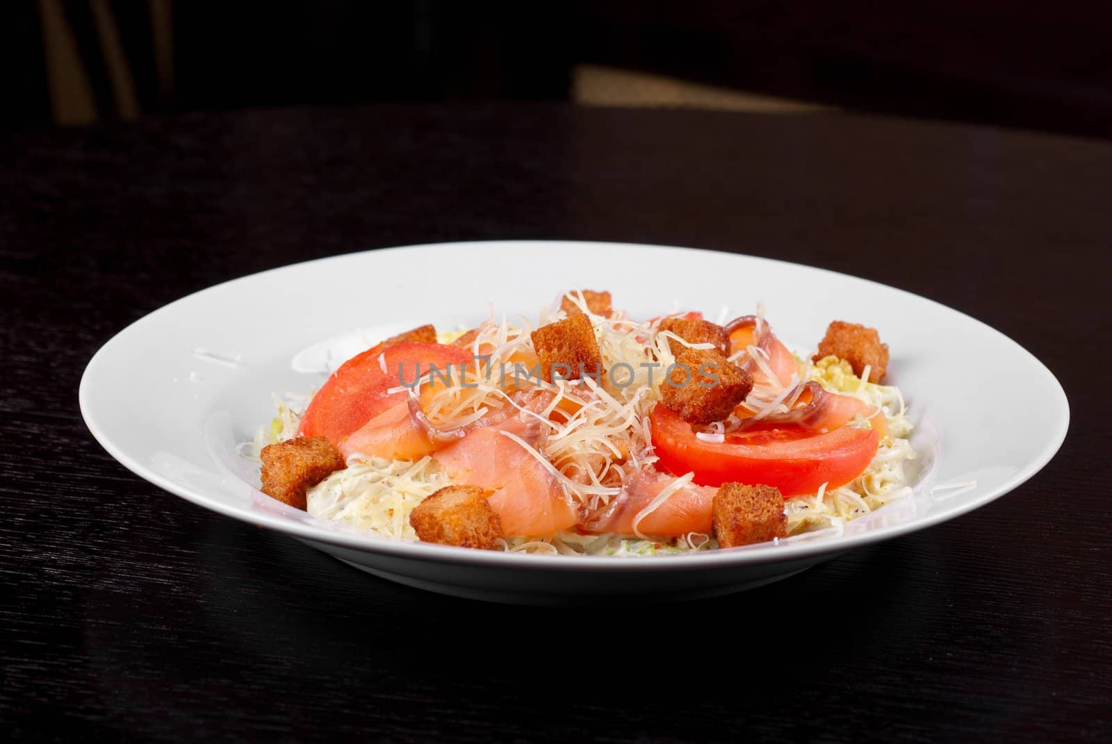 Salad of lettuce, chinese cabbage, tomato, garlic rusk, parmesan cheese, sauce and smoked salmon filet