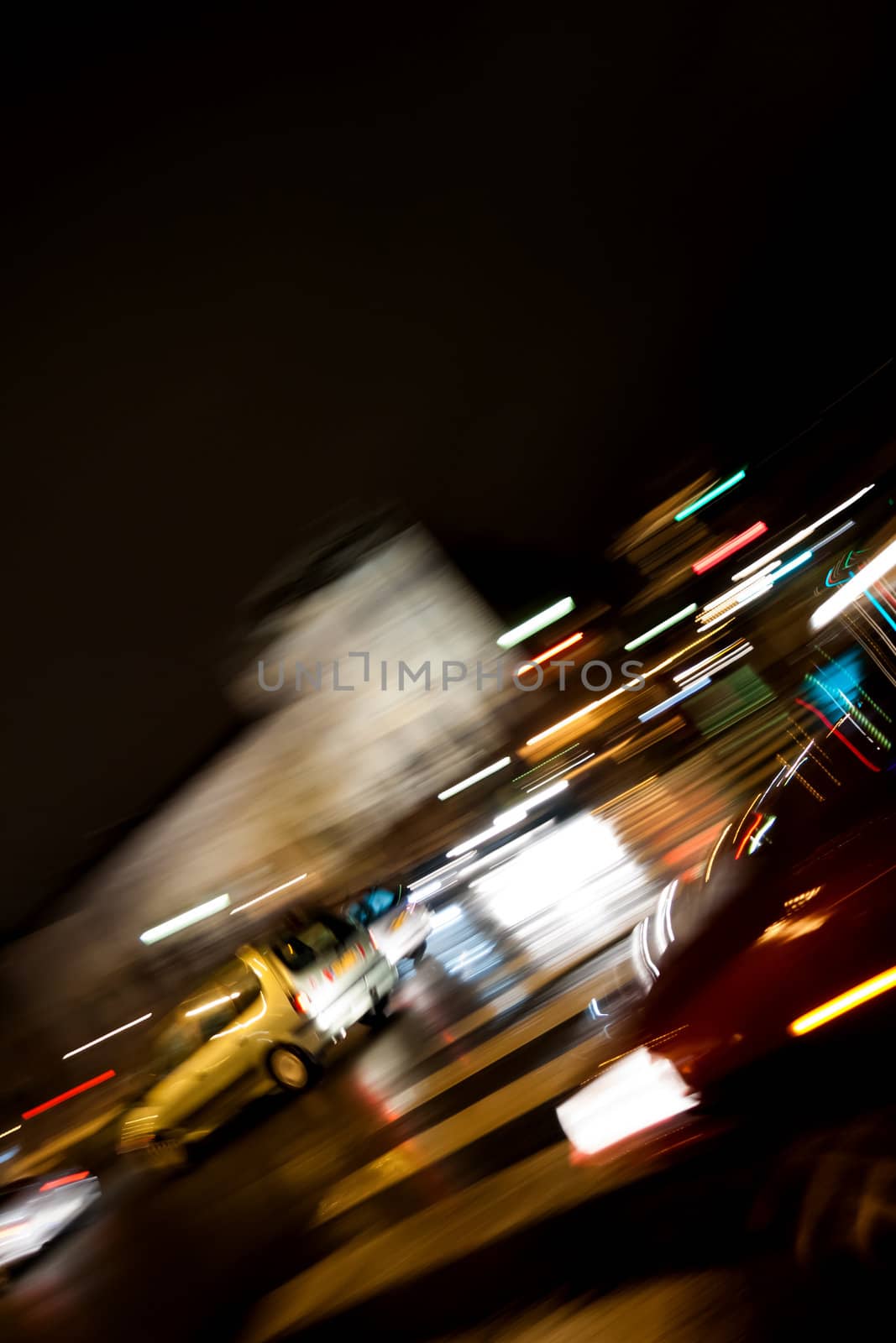 Traffic at night in a city. Wet road after rain. Intentionally blurred