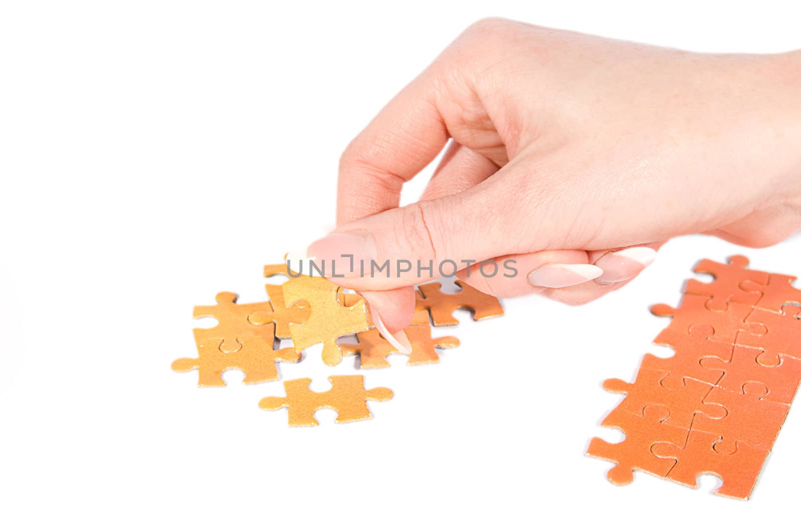 Woman hand putting right puzzle on white