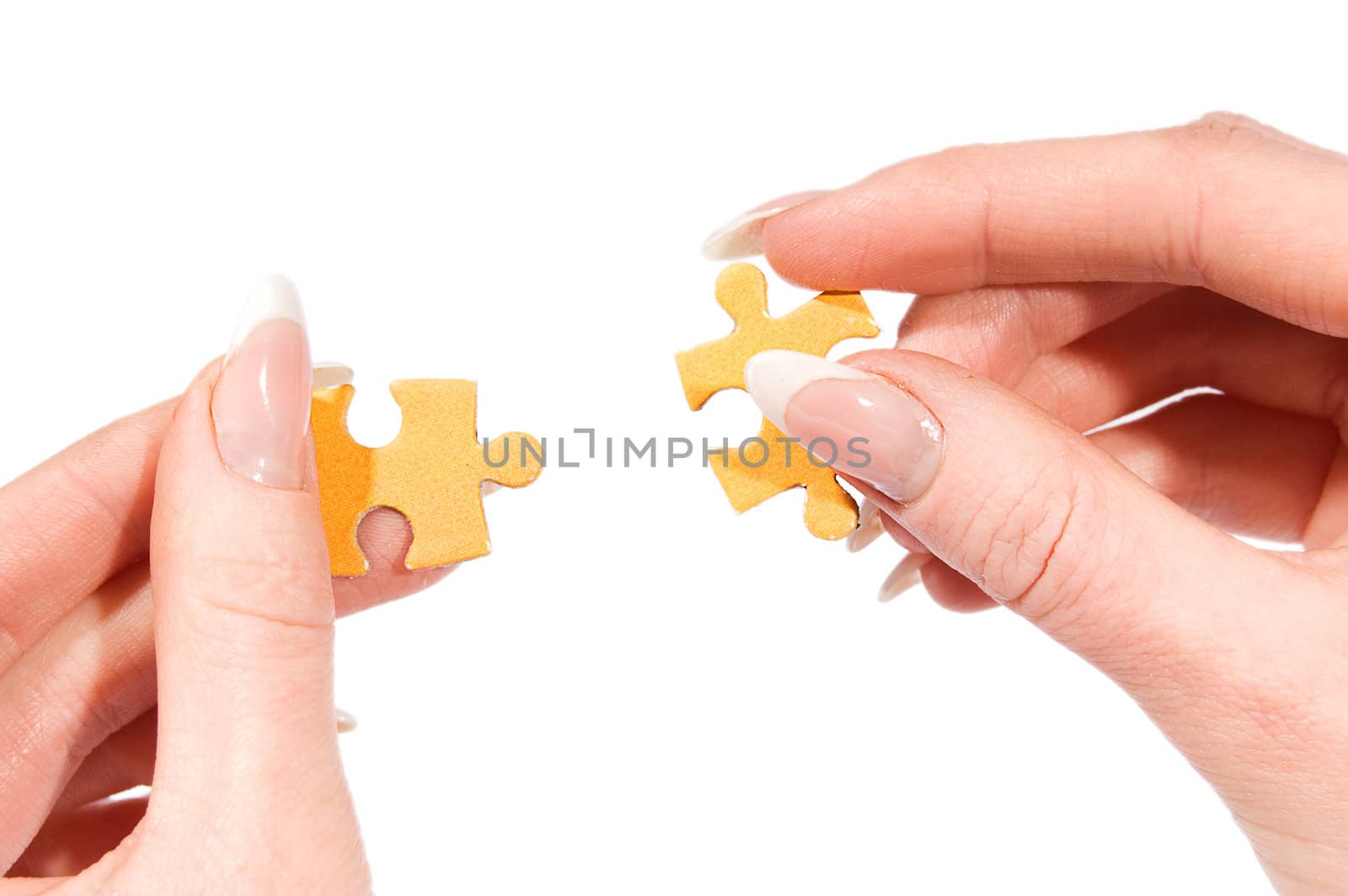 Female hands putting together right puzzle isolated