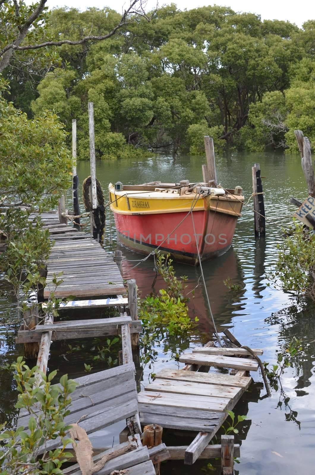 Old broken jetty and boat at Moreton Bay in south east Queensland, Australia.