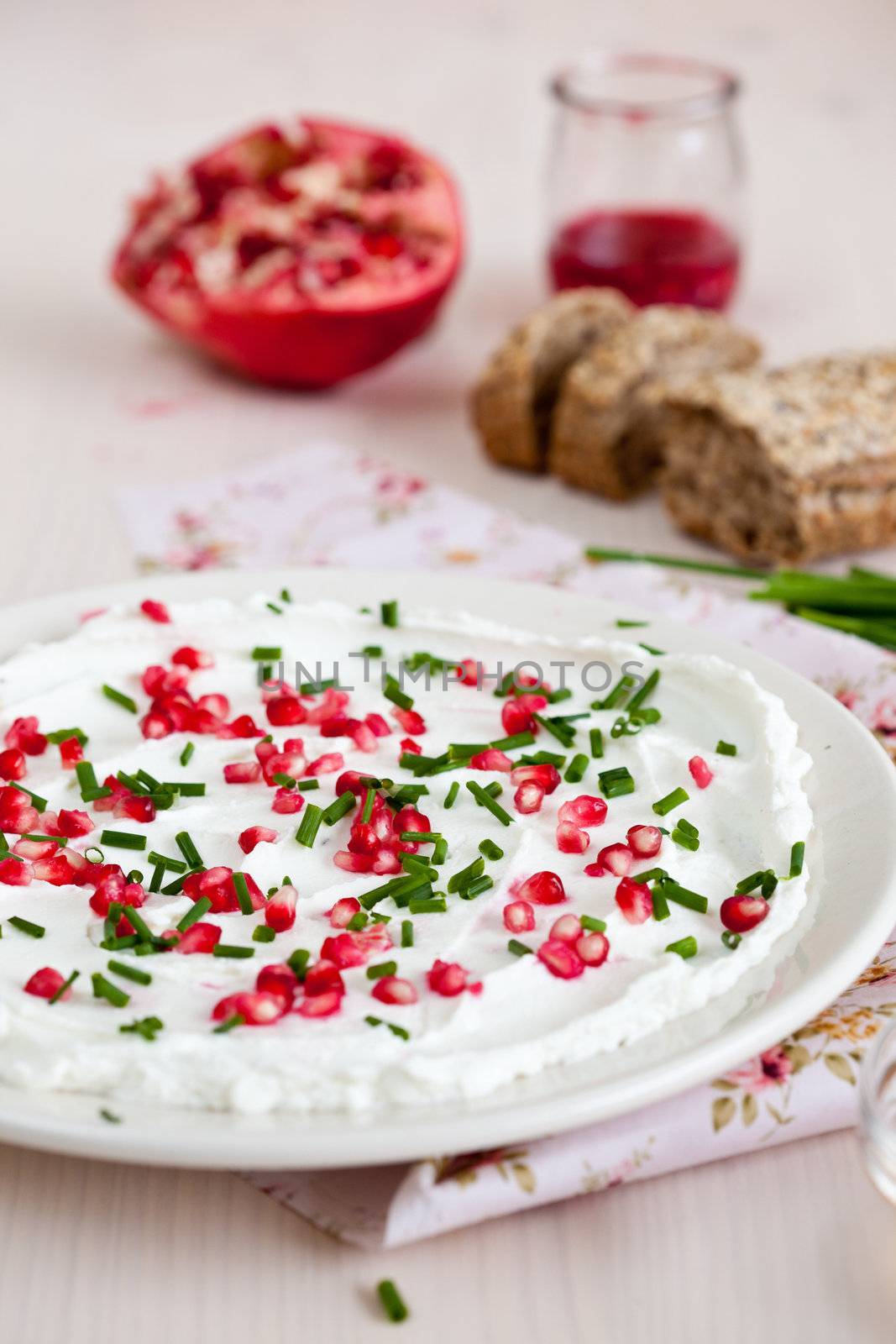 Creamy goatcheese with pomegranate seeds and chives