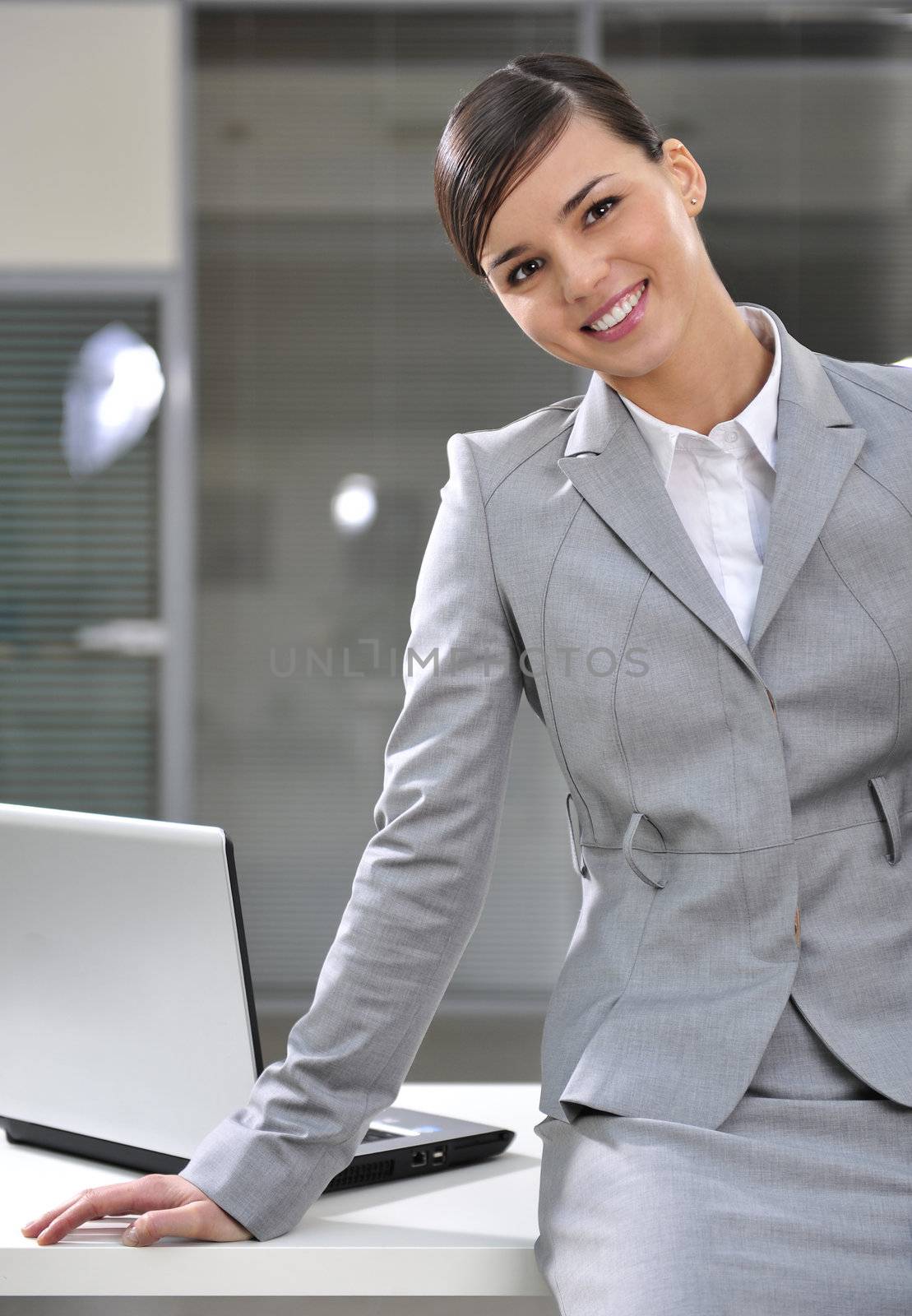 Happy business woman smiling in office with laptop