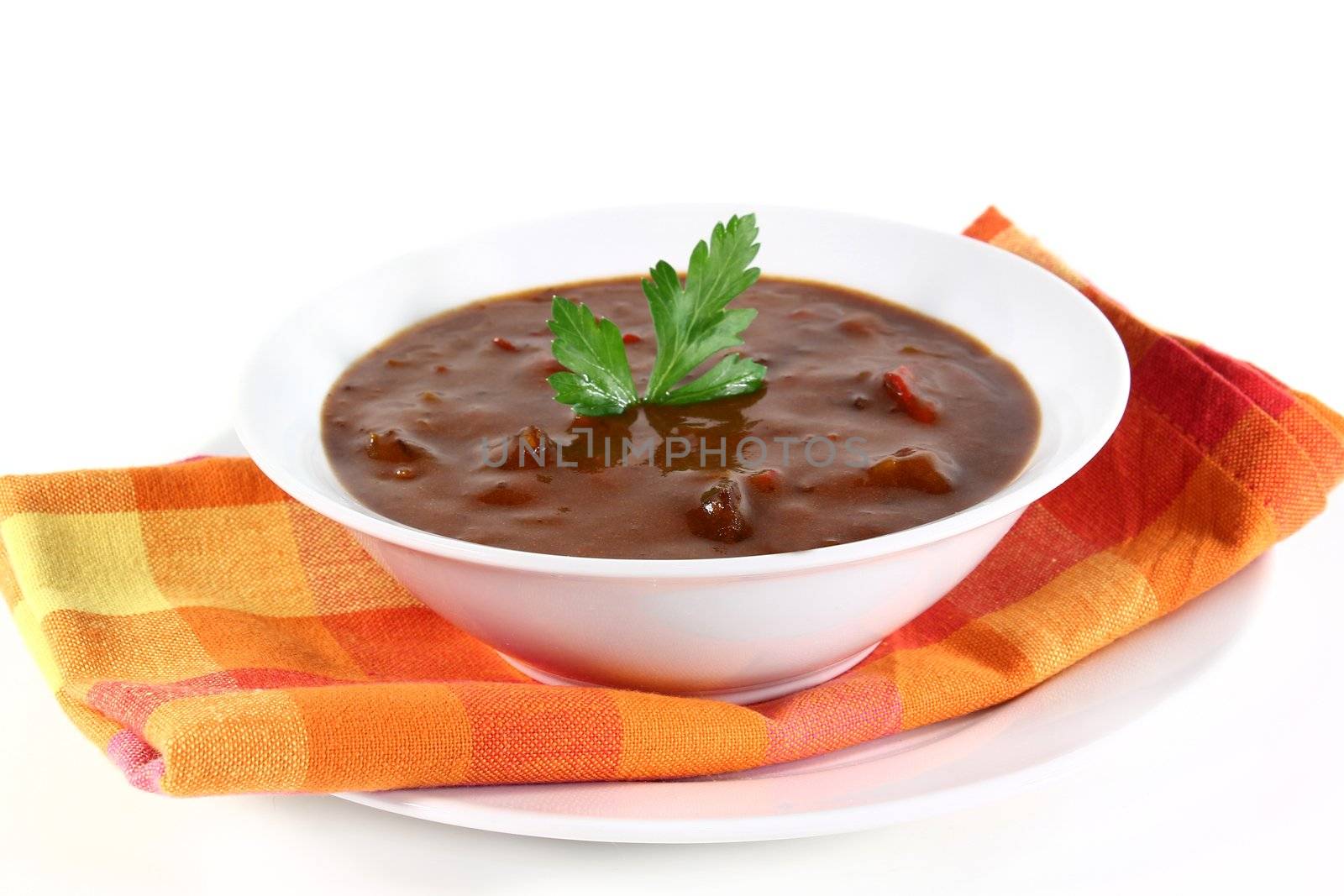 a bowl of goulash soup and fresh ingredients