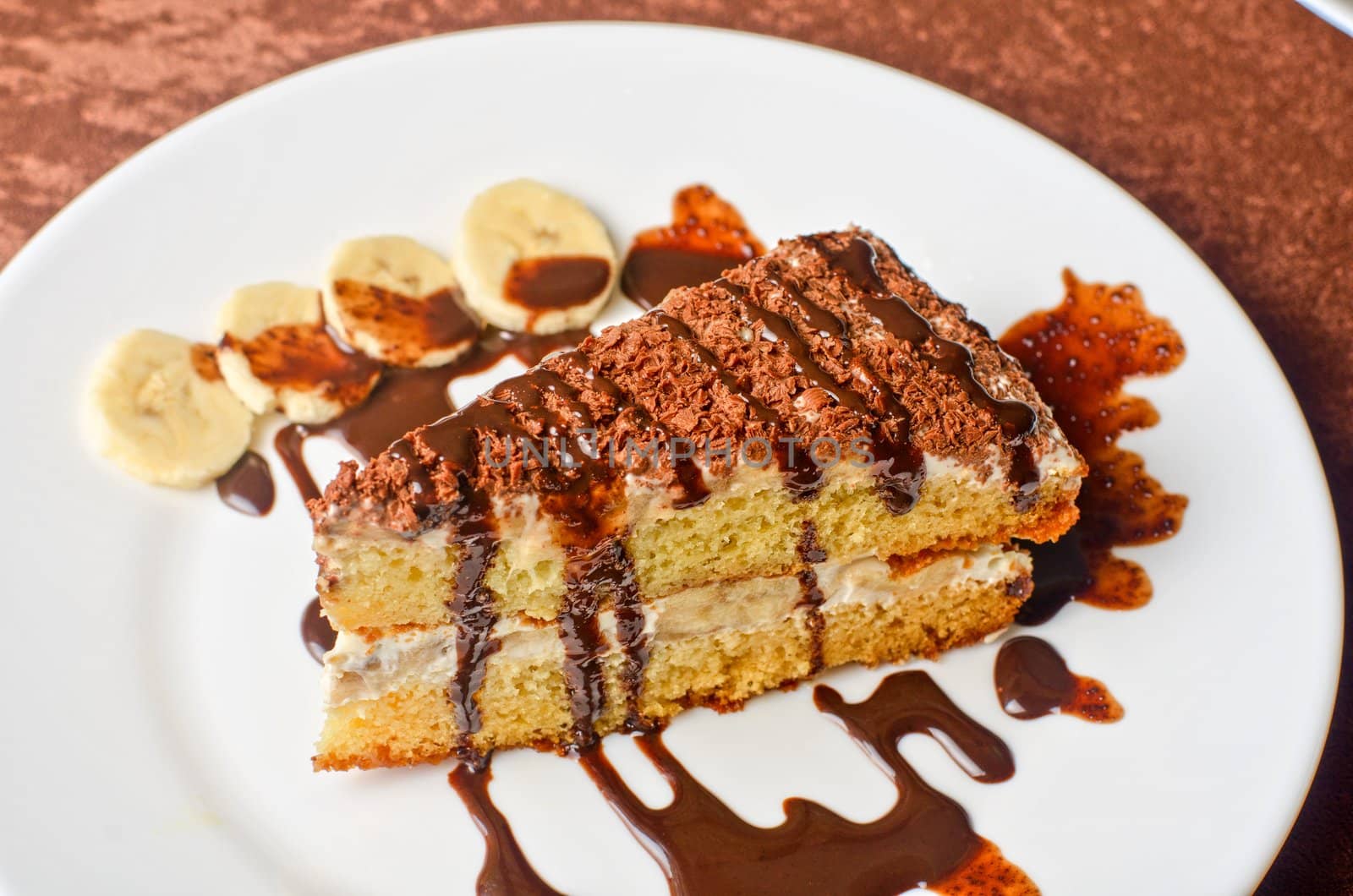 Dessert cake closeup with banana at plate