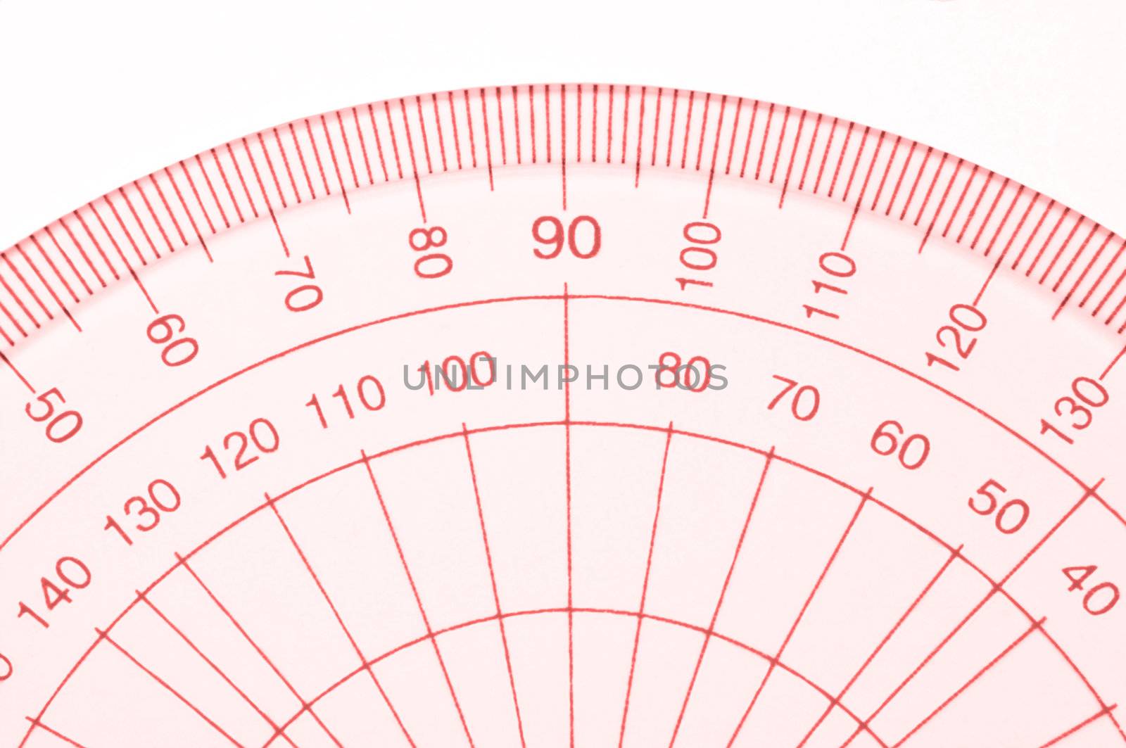 Close Up capturing a portion of a transparent plastic protractor arranged over white.