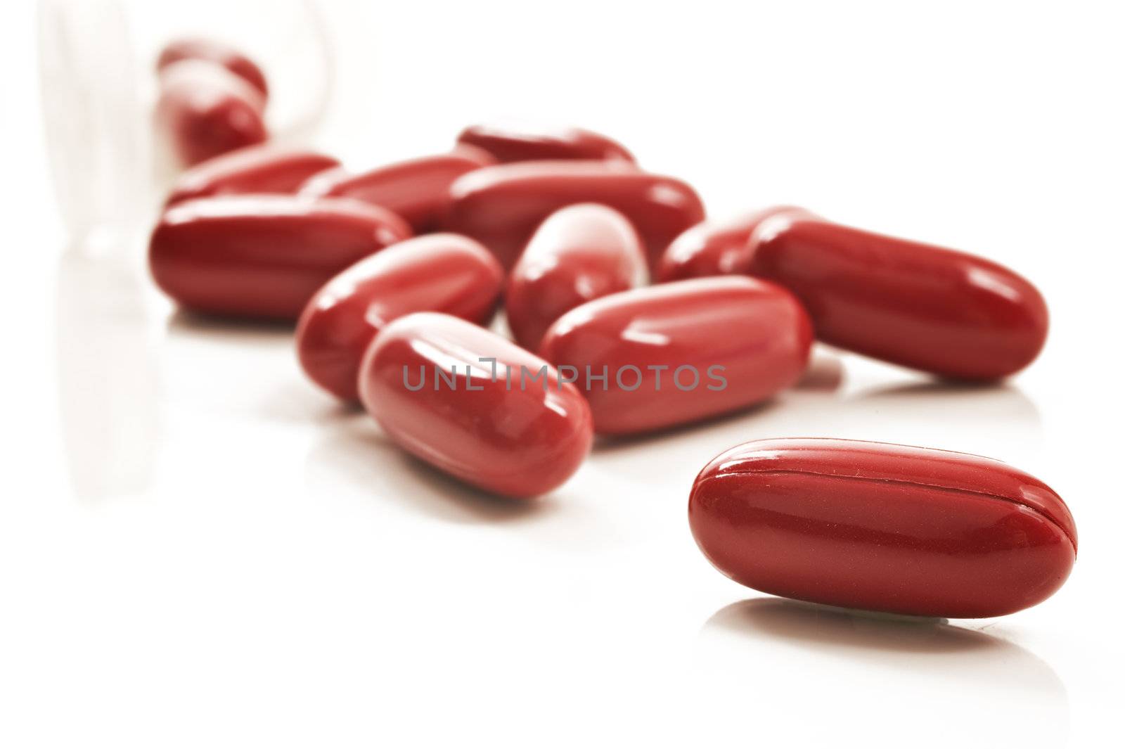 Red pills and pill bottle  on white background by tish1