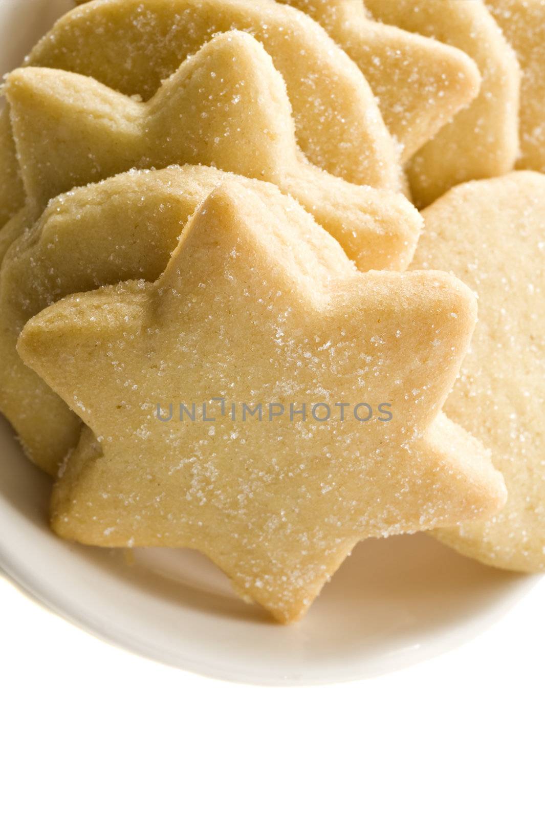 Star shaped homemade cookies in a white plate on white background