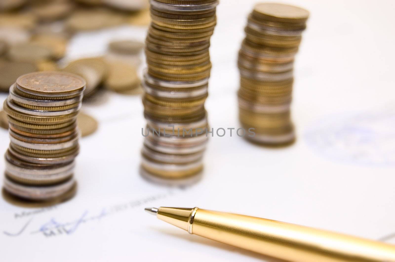 Coins and gold pen on  written contract background 