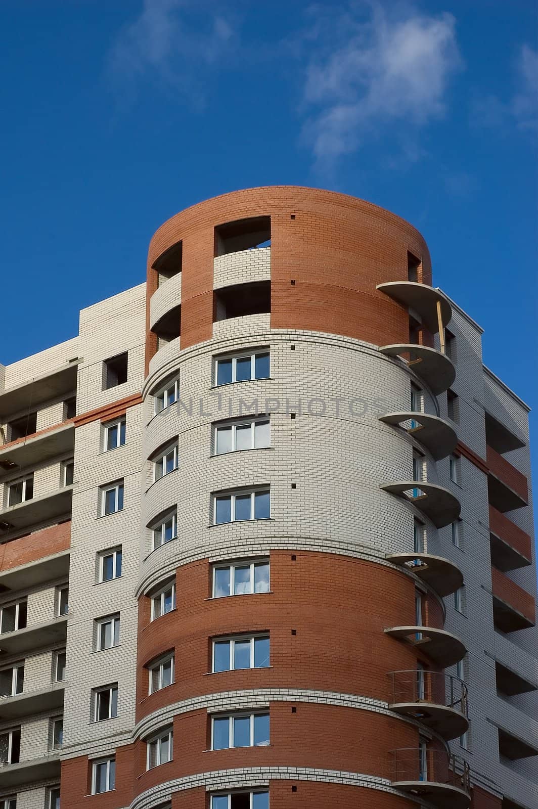 Modern multistory house of red and white bricks on  blue sky background