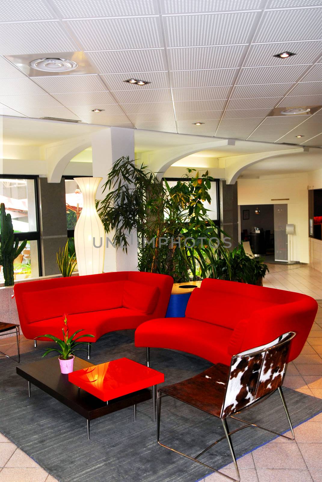 Interior of a modern european hotel lobby with red sofas