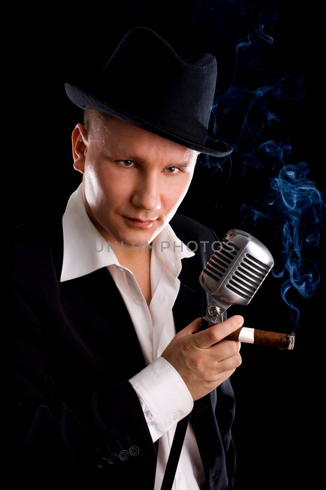 Jazzman and retro microphone in suit and hat