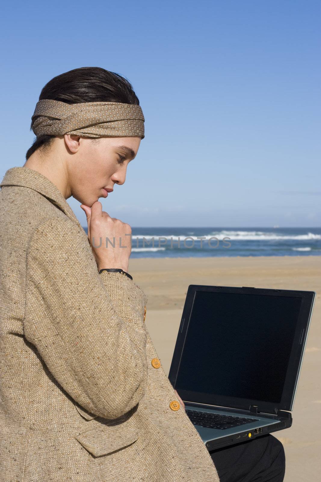 Professional working on his laptop at the beach
