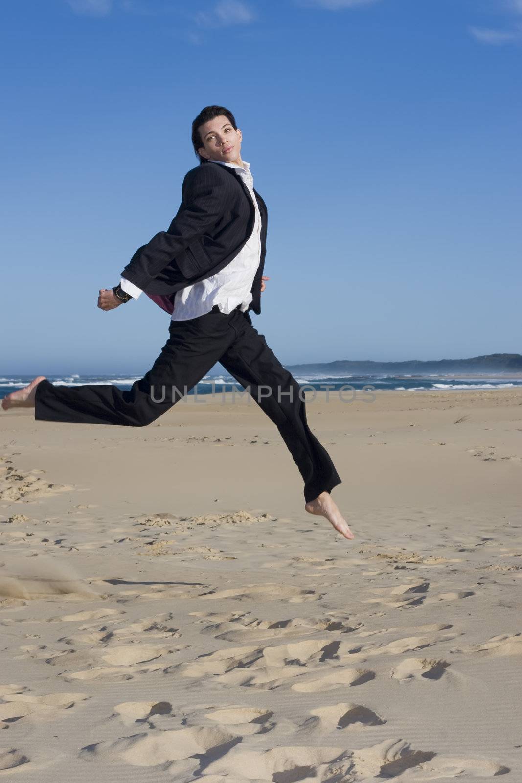 Young professional jumping wearing a business suit