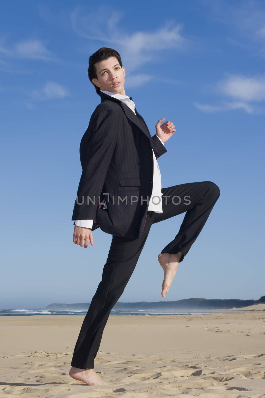 Young business man in suit on the beach