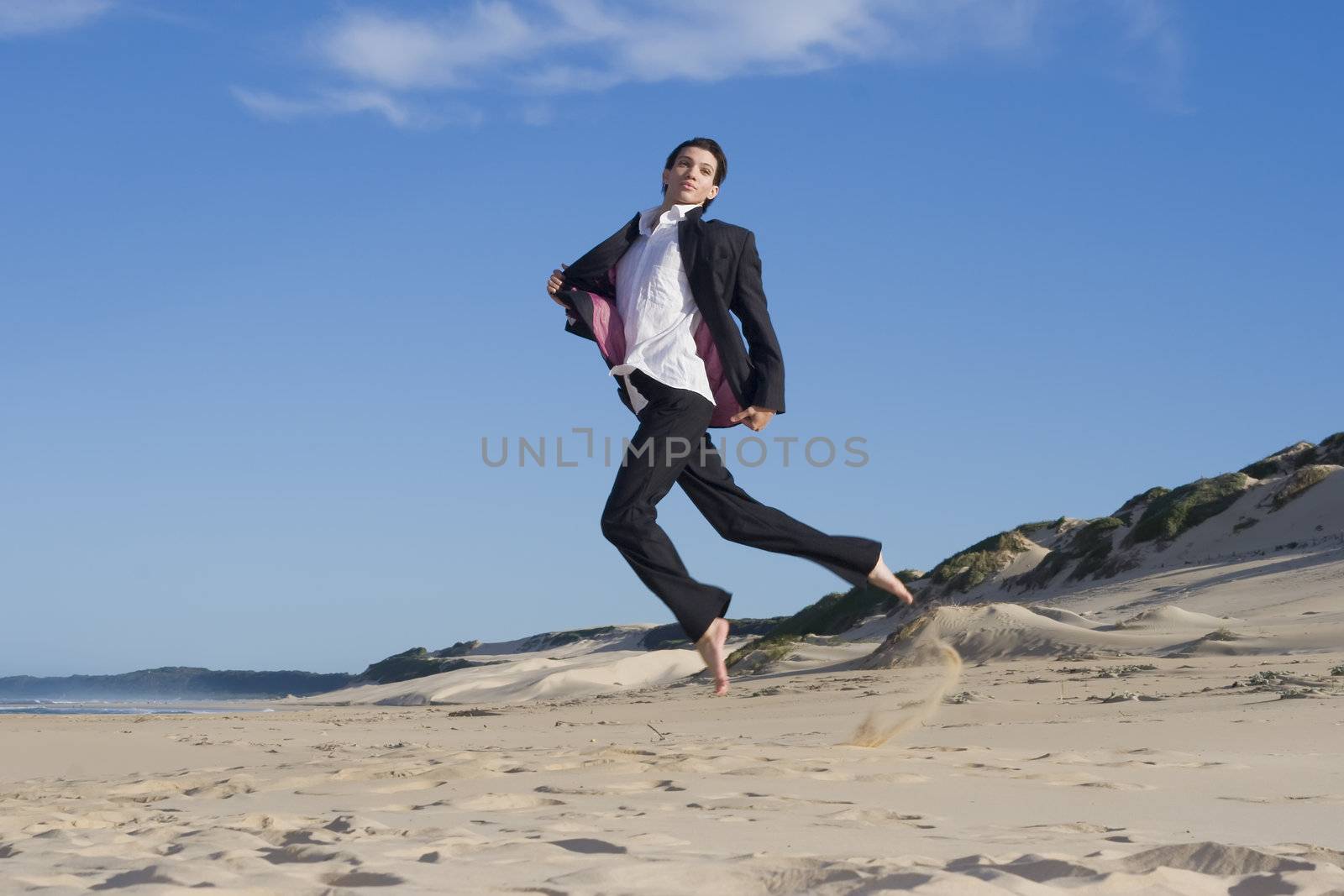 Young professional jumping in the air wearing a business suit