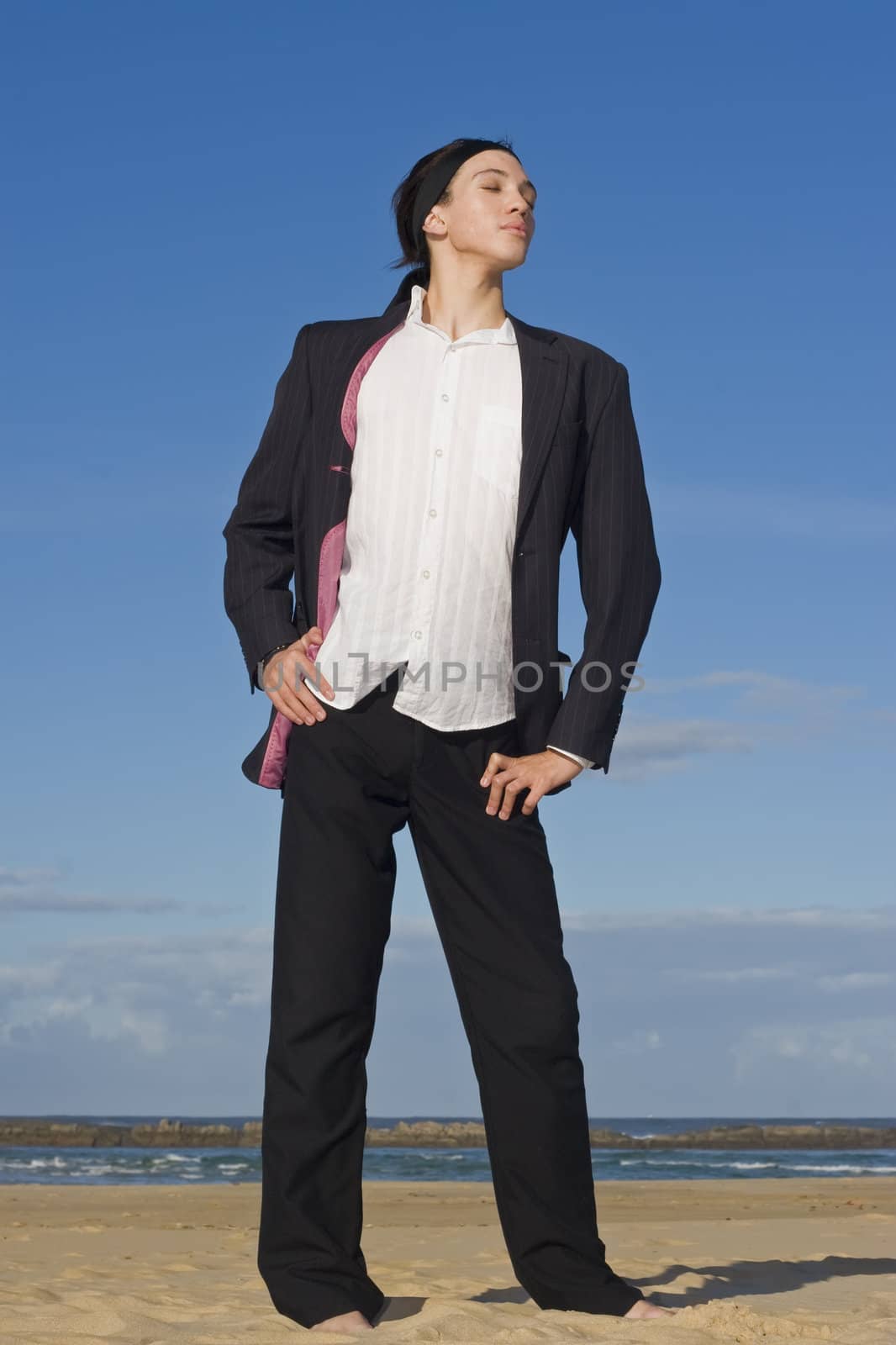 Business-man in suit standing on the beach