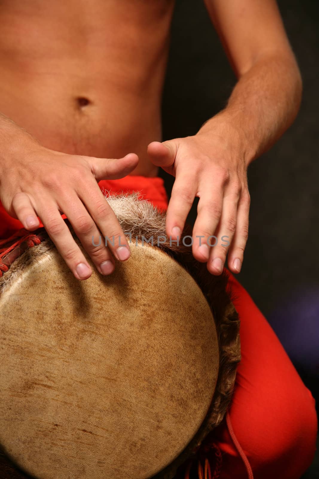 Man playing the djembe (nigerian drum) in studio