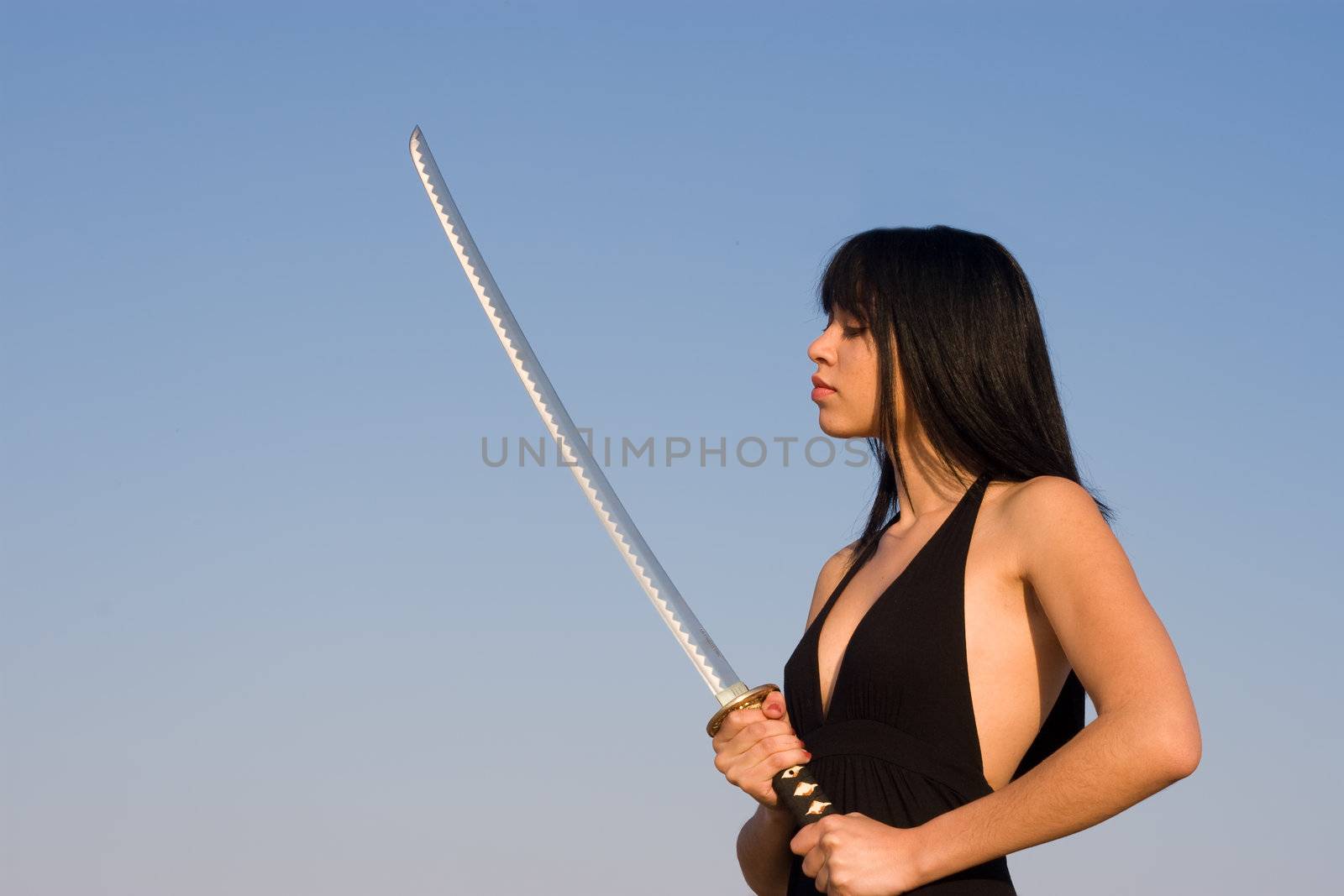 Asian model posing with a sword against blue sky