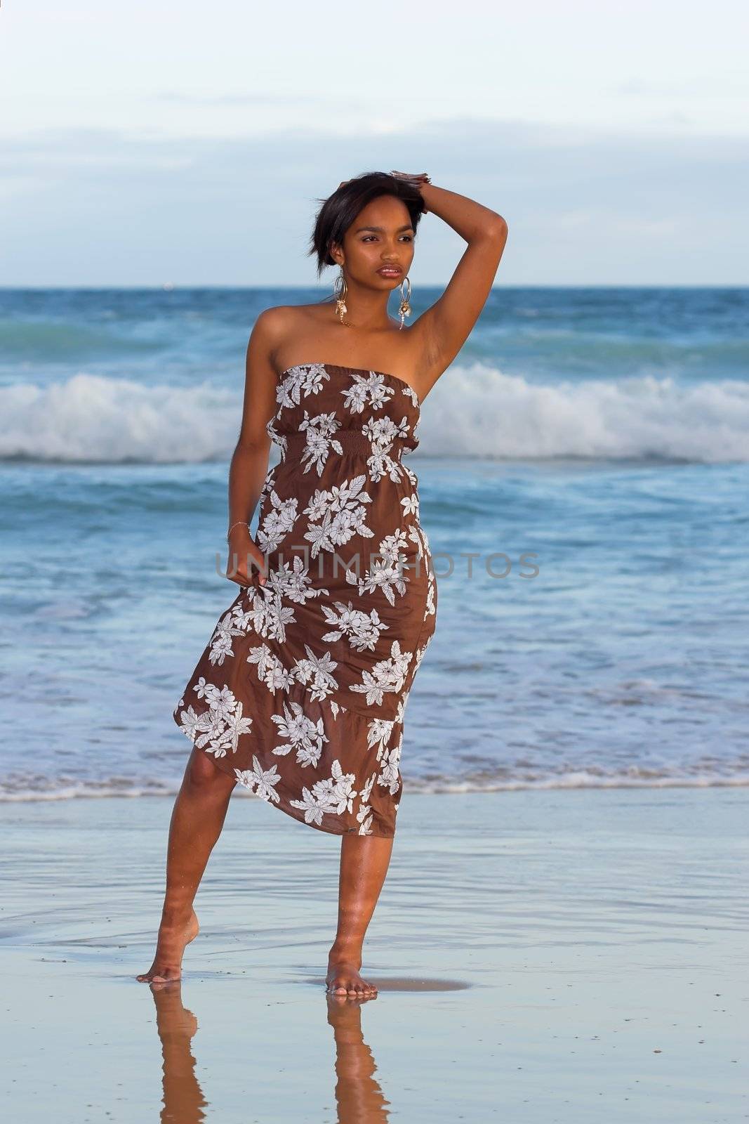 Ethnic model in brown floral dress at the beach
