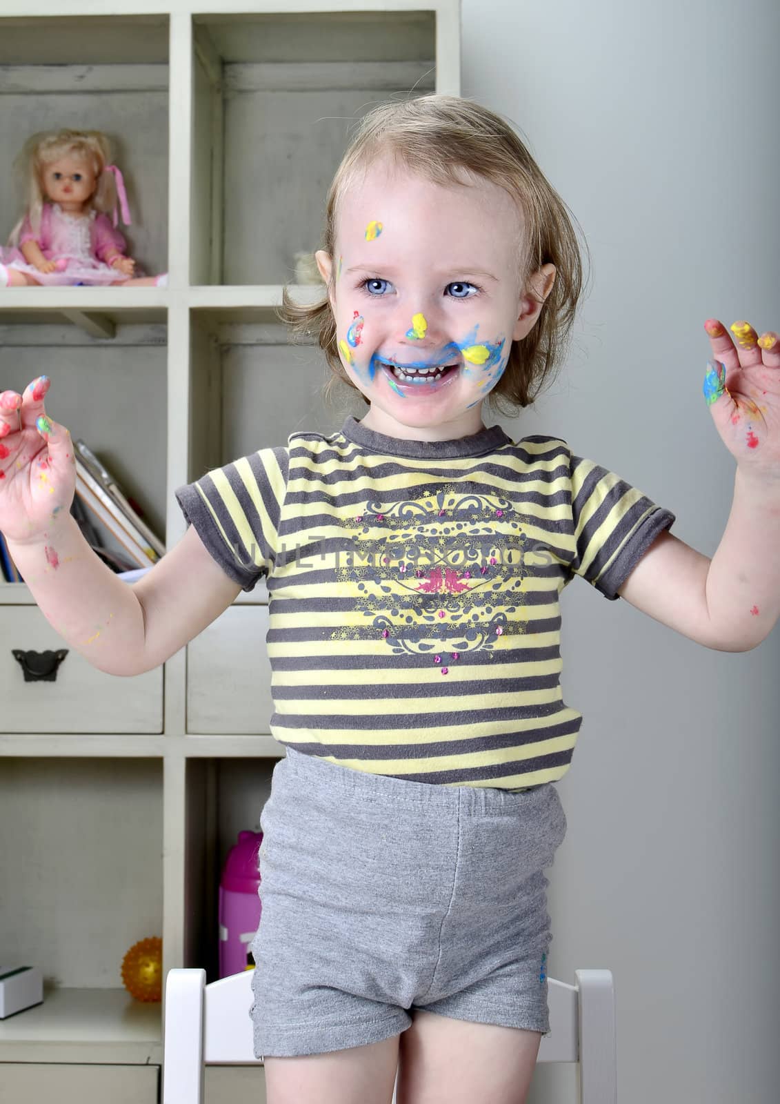 funny little girl and colored paints