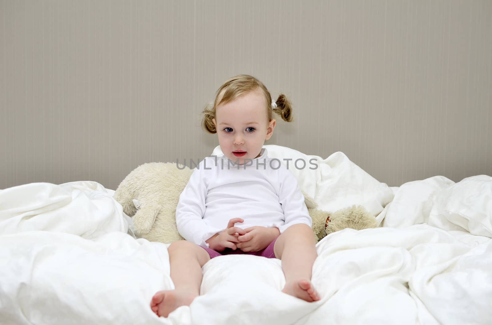 little girl sitting on a bed by dmitrimaruta