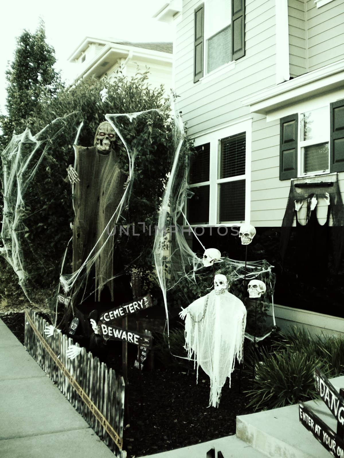 Spooky halloween decorations in front of a suburban home.