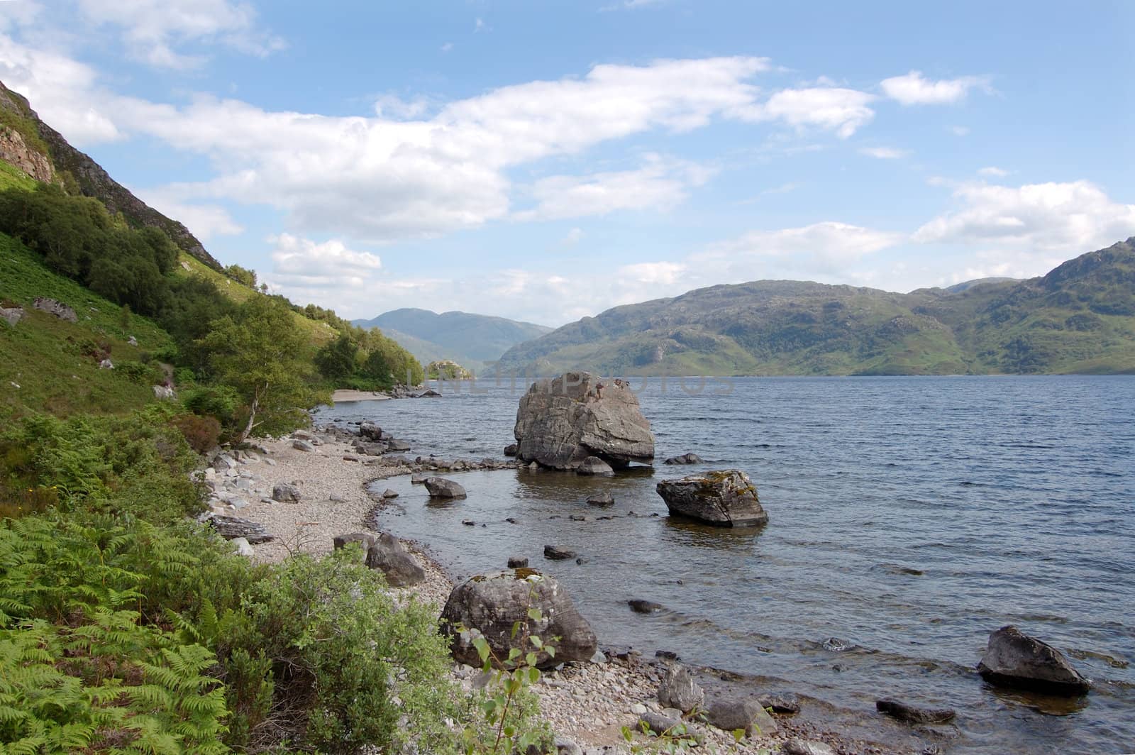 Looking toward the south Morar hills from the north shore of Loch Morar, Scotland with alarge rock on the loch foreshore