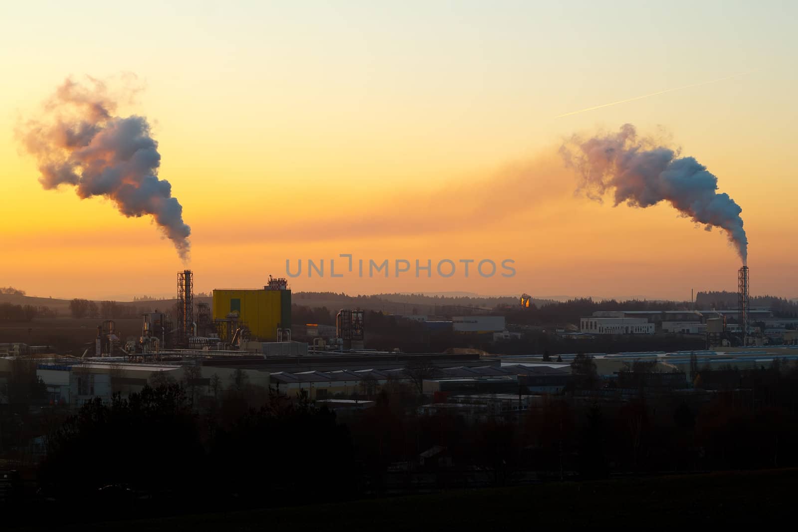 Sunrise silhouette of city landscape with smoking factory
