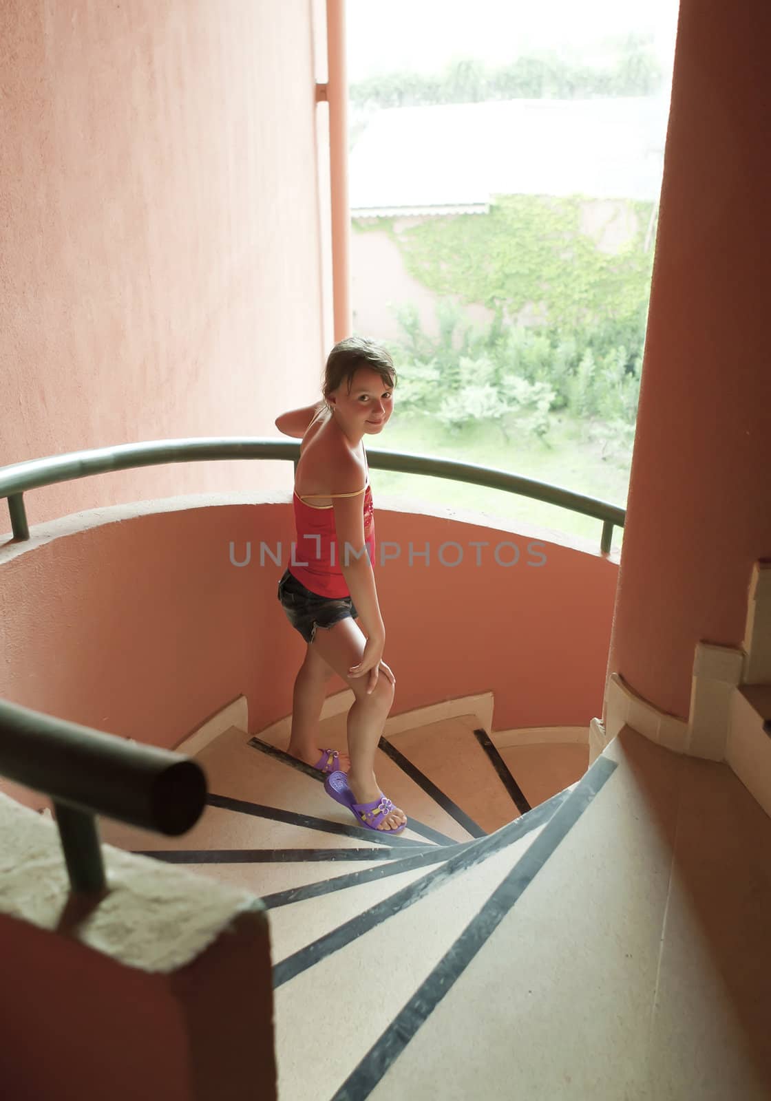 Portrait of a beautiful young girl  on red spiral staircase