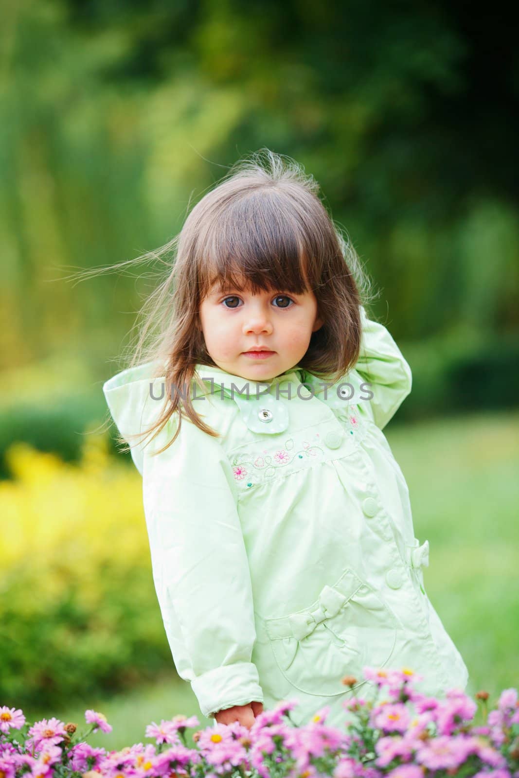 Clouse-up portrait pretty little girl in the park with a flower