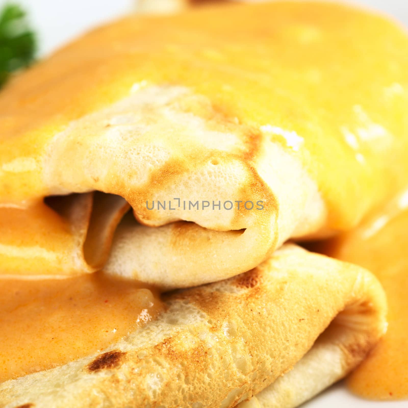 Hungarian-style crepe called Hortobagyi Husos Palacsinta (Crepe a la Hortobagy) filled with meat and served with sauce (Selective Focus, Focus on the front edge of the upper crepe)  