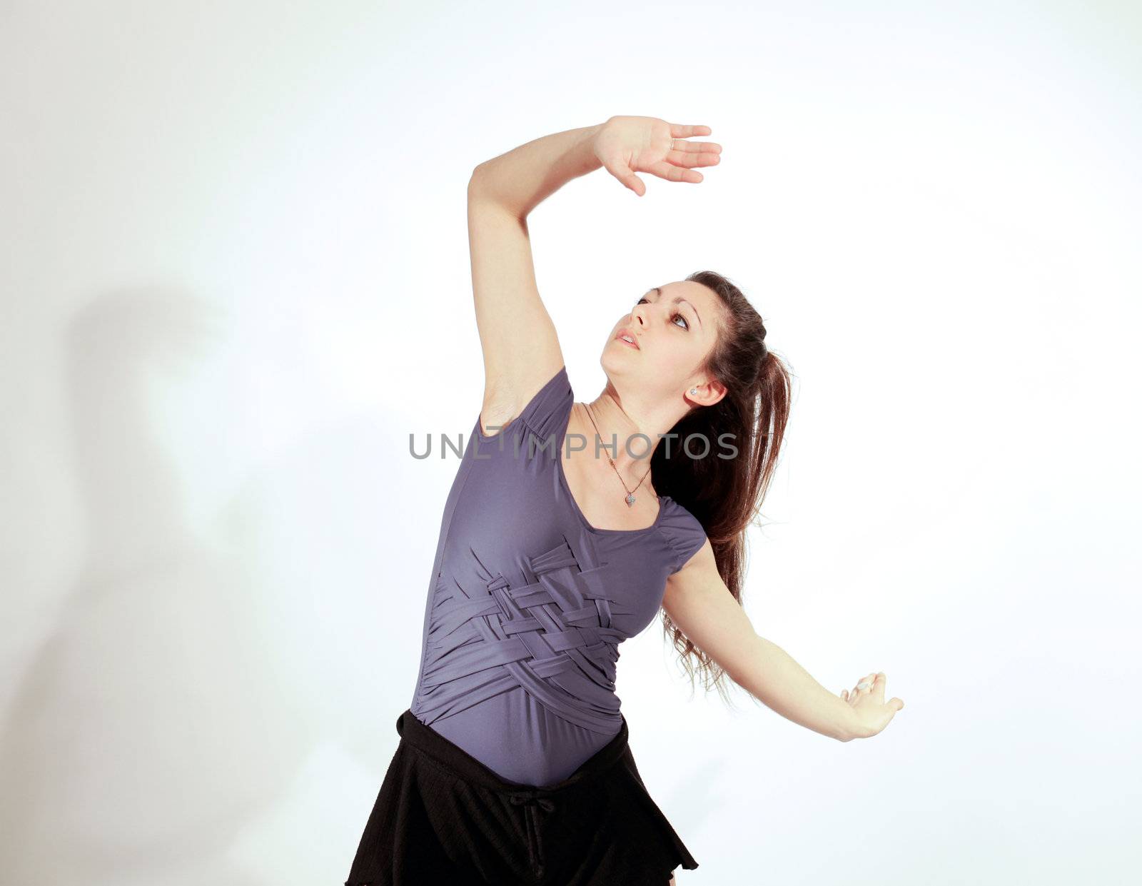 Young pretty teenage girl brunette Dancing in studio with long hair