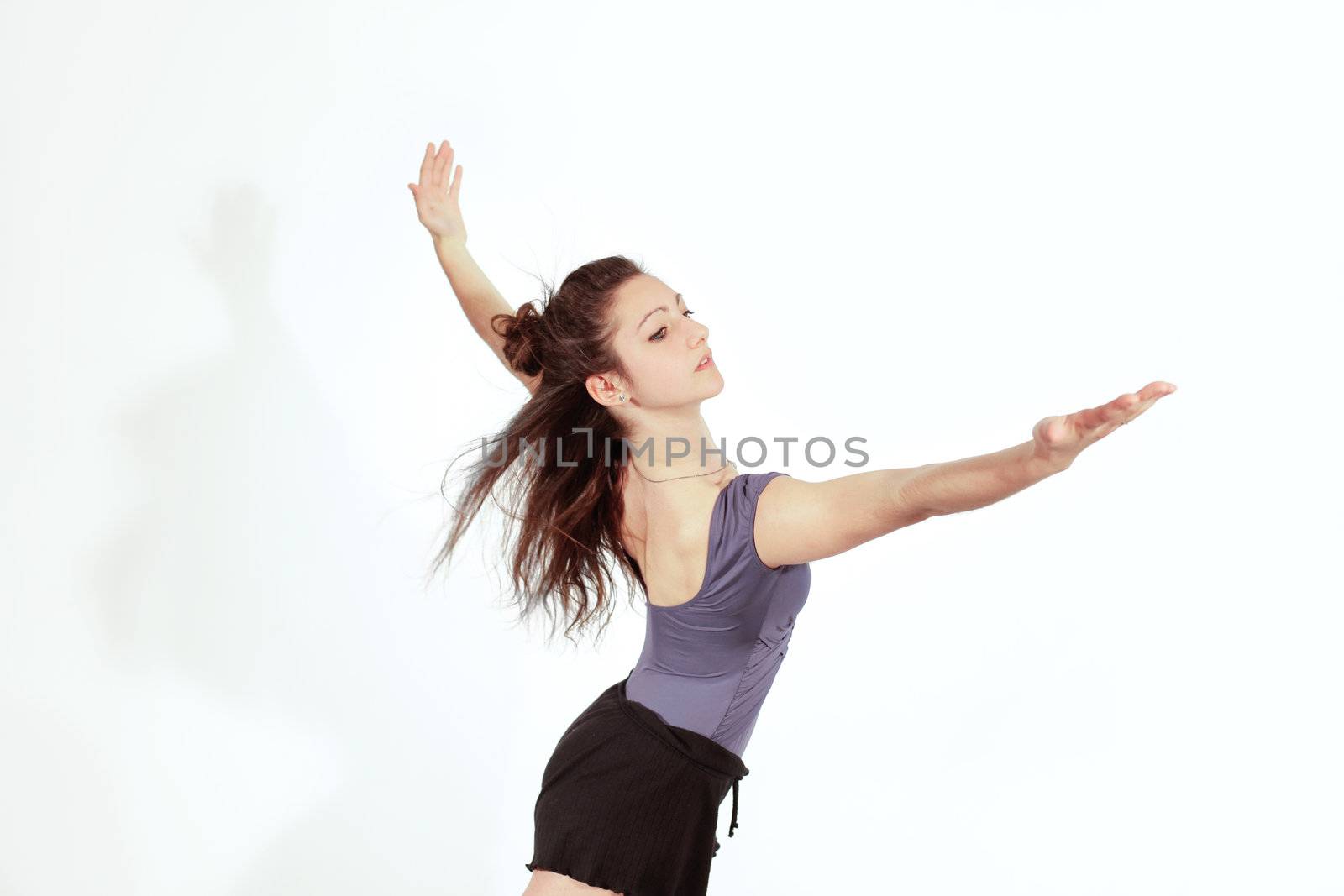 Young pretty teenage girl brunette Dancing in studio with long hair