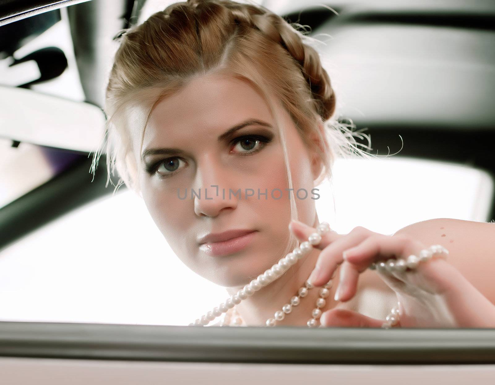   Young sexual blonde in the car. Pearl beads.