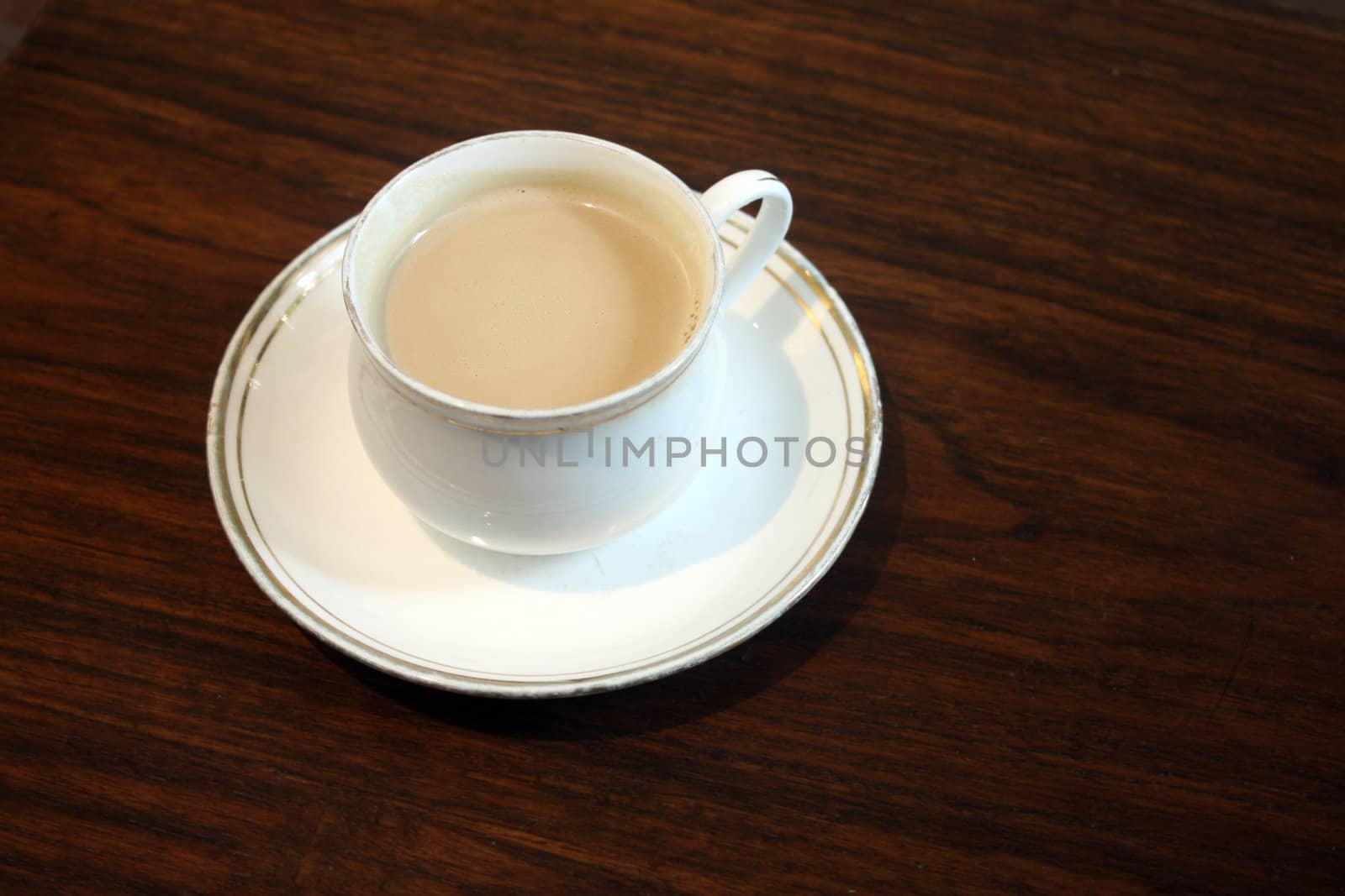 An old coffee cup on a wooden table.