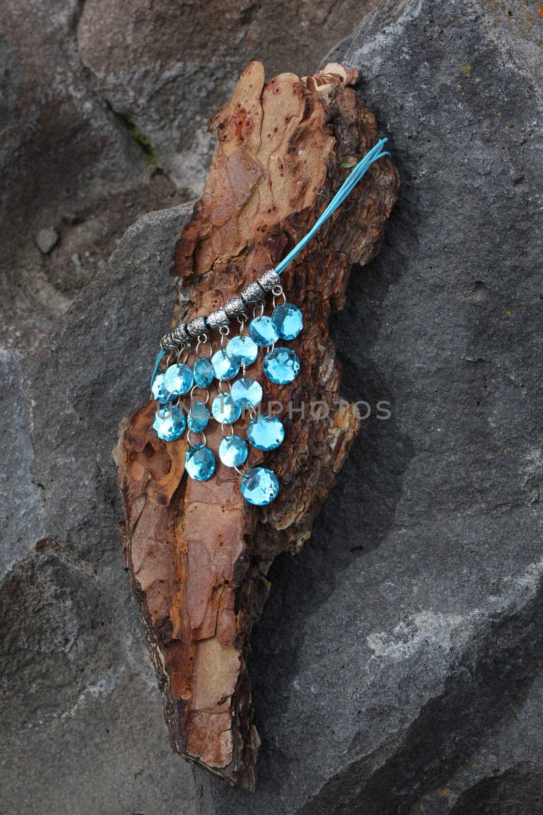 Blue gem necklace on a piece of bark