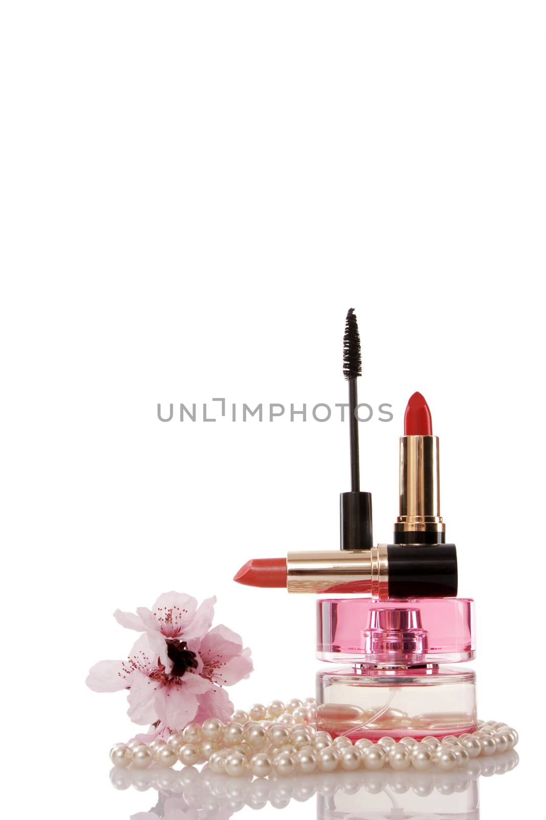 Pearls beads, cosmetics and cherry flower on white background