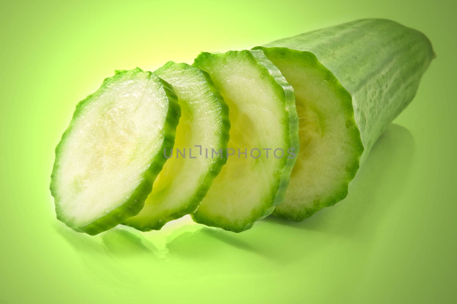 Close up of a partially sliced fresh cucumber with green light effect filter