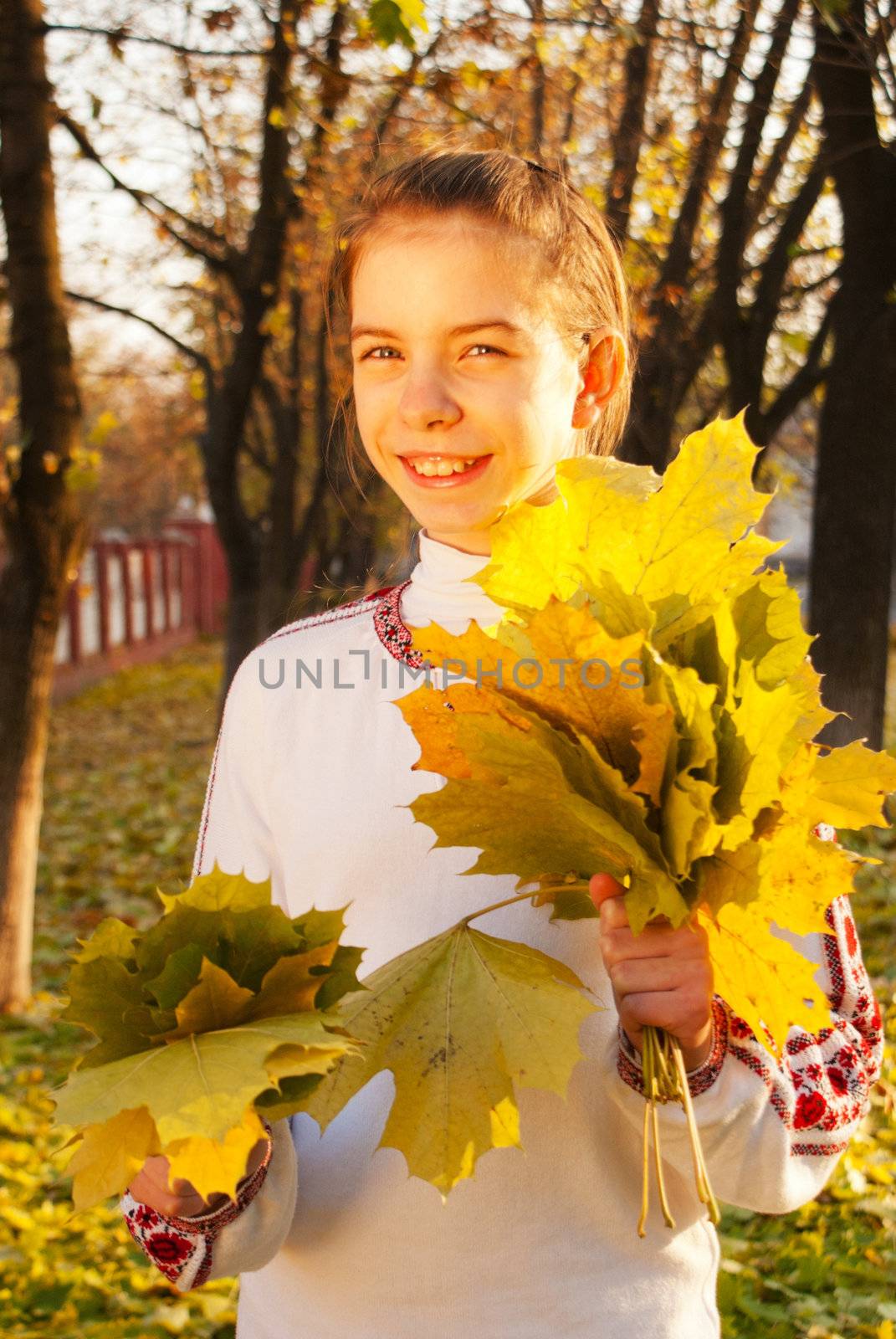 Girl with leaves at fall time
